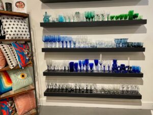 Colorful blue and green vintage style glassware on shelves.