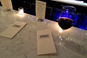 Glass of wine and menu at Apogee