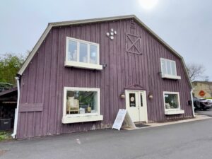 A light purple barn with a Cleo + Kin sign at the entrance