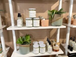 White candles and houseplants in clay pots on white shelving
