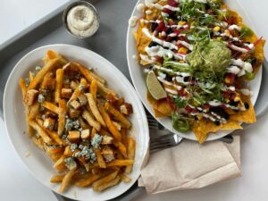 Loaded fries and nachos on a tray at Strong Hearts Syracuse