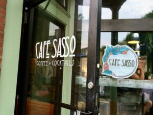 Entrance to Cafe Sasso with their logo on the glass door.