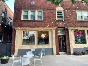 Brick building with lights strung up outside over an outdoor patio with seating.