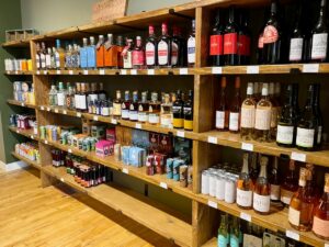 Bottles of non-alcoholic spirits, wine, and cocktails on shelves at AltBar.