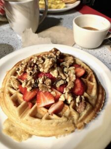 Funk 'n Waffles vegan waffles with strawberries and walnuts and a cup of coffee