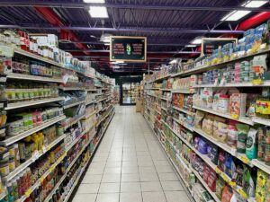 An aisle at Green Planet Grocery showing condiments, pasta, crackers, coffee and more