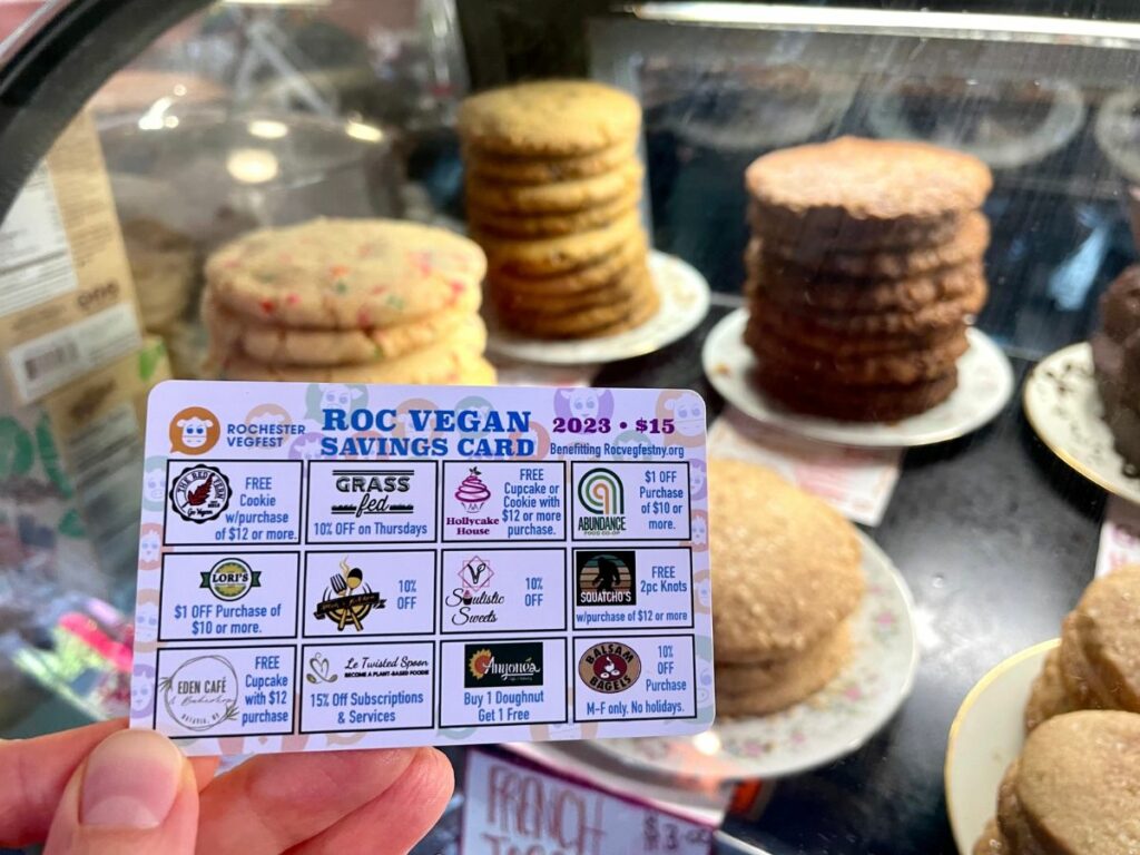 Roc Vegan Savings Card held in front of the dessert display case at The Red Fern.
