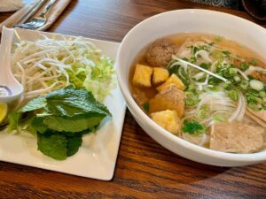 Bowl of vegan pho with the toppings on the side.