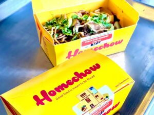One closed box and one open box showing the vegan soba noodle stir fry.
